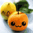 Animated icon shows a smiling orange fruit with eyes and mouth, next to a lemon and green leaves on the left; right side displays an orange juice carton labeled 'ORANGE' with a large orange illustration.