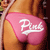 Pixelated image of a person wearing a pink garment with white text, showing a partial torso and arm against a brown background.
