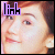 Pixelated face with light skin and brown hair, wearing a purple 'link' text overlay on the left side.