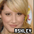 A pixelated image of a person with blonde hair and yellow flower accessory, overlaid with text reading ASHLEY.