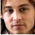 Pixelated close-up of a person's face with light skin tone, brown eyes, and dark hair visible on the left edge.