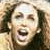 A pixelated image of a person with light brown hair and open mouth on left, adjacent to cyan text 'MI MI' on black background.