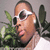 A person wearing white sunglasses and a white shirt with green foliage in the background, shown across four