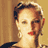 Pixelated static image of a person's face with brown hair and red lips against a beige background, rendered in low-resolution 256x256 pixels.