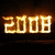 Animated digital display of '2008' in glowing orange-yellow numerals against a dark background, with visible pixelation and slight variations in brightness across frames.