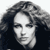 Static grayscale pixel art portrait of a person with curly hair, cropped to show head and shoulders against dark background.