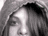 A person with dark hair and green eyes wears a hooded garment that changes color across frames, showing gray, brown, red, and black variations.