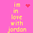 Pixelated yellow text on pink background reads "im in love with jordan" across four lines, accompanied by red heart and starburst symbols.