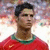 Pixelated portrait of a person with short dark hair wearing red clothing and green collar, set against blurred background.