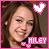 Pixelated portrait of a smiling person with long brown hair, pink border, heart symbol above head, and 'MILEY' text on lower right.