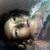 A pixelated static image shows a person with light skin and dark hair lying down, eyes closed, against a blurred background of muted tones.