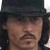 Pixelated close-up of a person wearing a dark top hat and long dark hair, with visible facial features including a mustache and light skin tone.