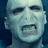 Pixelated image of a pale-skinned character with a wide-open mouth, surrounded by pixelated text phrases on a black background.