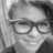 Black-and-white pixelated portrait of a person wearing rectangular eyeglasses, with visible hair and partial facial features in grayscale tones.