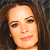Static pixelated image of a woman's face with long brown hair, visible facial features including eyes, nose, mouth, and ear, rendered in warm tones on a dark background.