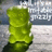 A pixelated green cylindrical object with a dark base against a blurred background of gray and white tones.