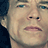 Static 48x48 pixel icon showing a close-up of a person's face with light skin tone, blue eyes, and neutral expression against dark background.