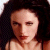 Static pixelated image of a person's face with dark hair and light skin, cropped to show upper shoulders against a black background.