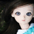 A pixelated anime-style character with long dark hair and blue eyes, wearing a white top with turquoise patterned fabric.