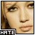 Pixelated close-up of a person's face with light skin tone, brown eyes, and dark hair; black border contains white text 'HATE' at bottom-left.