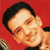 Pixelated static image of a person's face with dark hair against a solid red background, showing partial shoulder and chest area in low-resolution 50x50 icon format.
