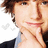A pixelated image shows a person with brown hair resting their chin on one hand, next to bright cyan background with pink text reading "Cute".
