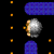 Pixelated image of a silver sphere with orange and brown accents, surrounded by small orange squares and blue rectangular shapes on a black background.