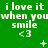 Green background with repeated white text 'i love it when you smile <3' and small white symbols like +, *, ×, and dots scattered across the image.