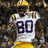 A pixelated image of a football player in a white jersey with number 80, yellow helmet, and yellow pants, set against a purple background with text elements.