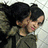 A young girl with dark hair in a high ponytail wears a green jacket and pink lips, shown in three sequential poses against a light background