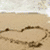 Animated sequence showing a heart shape formed by hands on sand, transitioning to a heart-shaped cloud at sunset.