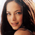 Static pixelated image of a person with long dark hair and light skin, cropped to show upper shoulders and face against a white background.