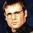 A 48x48 pixel buddy icon split into two sections: a left-side portrait of a man with short brown hair and glasses against a dark background, and a right-side green section with bright green text reading "Original Icons .com".