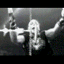 Animated sequence showing a wrestler performing moves in an arena, transitioning from black-and-white to sepia tones with blue lettering and green text elements.