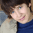 A pixelated image of a person with brown hair and blue eyes wearing a dark blue turtleneck sweater, next to text on a bright cyan background.
