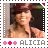 Alicia Keys in a maroon hat and brown jacket, smiling with hand near face, framed by dotted border with pink and red stars and 'ALICIA' text below.