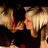 Two figures with dark and light hair kiss in a sequence showing slight head movement against a black background.