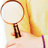 A split-screen image shows a hand holding a magnifying glass on the left and a person with long brown hair and a pink headband on the right, with 'NANCY DREW' text below.