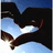 A pixelated static image shows a dark silhouette of an orca whale against a light blue sky with white clouds.