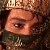 Pixelated close-up of a person's eye and forehead with a crown-like object above, dark background, and visible pixelation.