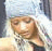 Pixelated image of a person with light-colored hair wearing a white head covering, next to green text reading 'Genie In A Bottle' on black background.