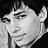 Pixelated grayscale portrait of a person with short hair, neutral expression, and visible ear against dark background.