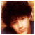 Pixelated image of a person with dark hair and warm lighting on the left, next to text reading "Nick Jonas" in white letters on a dark green background.