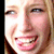 A four- shows a person with light hair smiling broadly, displaying teeth and a gap in the upper front teeth, with visible eye and mouth details