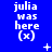Blue background with repeated white text 'julia was here (x)' in three , plus small white and light blue pixelated symbols scattered across the image