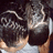 A person with dark curly hair and a light gray shirt viewed from behind, showing the back of their head and shoulders.
