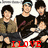Group of people holding guitars with red text overlays changing from 'I LOVE' to 'BE!' and '=D'