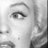 Grayscale close-up of a human eye with defined eyelashes and eyebrow, set against a pixelated background.