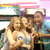 Pixelated image of two figures with light brown hair embracing, one figure has dark eyes and a white top, background includes pink and blue horizontal bands.