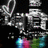 Pixelated icon with large stylized text, colorful abstract shapes at bottom, and scattered small colored pixels on dark background.